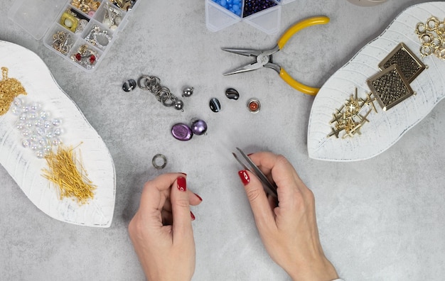 Une femme crée des bijoux faits à la main Préparation de perles à la main
