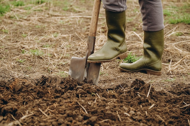 Une femme creuse la terre dans un champ Travaux agricoles au printemps dans le champ Préparation de la terre pour planter des moutons au printemps