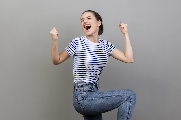 Femme criant de joie en levant les poings pour célébrer une victoire incroyable