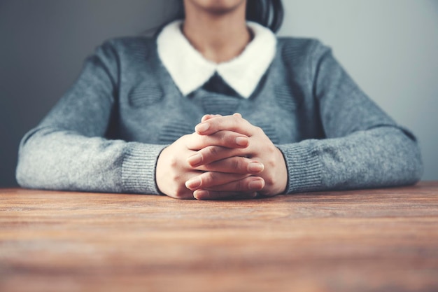 Femme croise le doigt sur la table