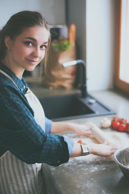 Une femme cuisinant dans une cuisine avec un sac de tomates sur le comptoir