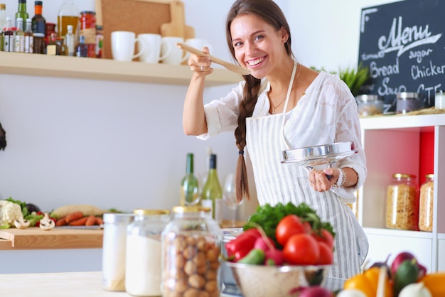 Femme de cuisine dans la cuisine avec une cuillère en bois. femme de cuisine