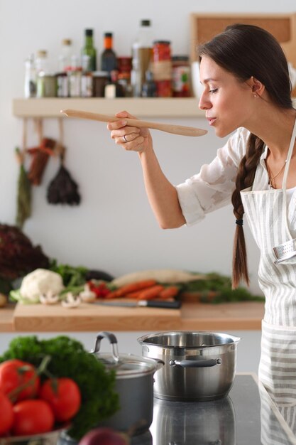 Femme de cuisine dans la cuisine avec une cuillère en bois