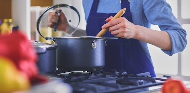 Femme de cuisine dans la cuisine avec une cuillère en bois