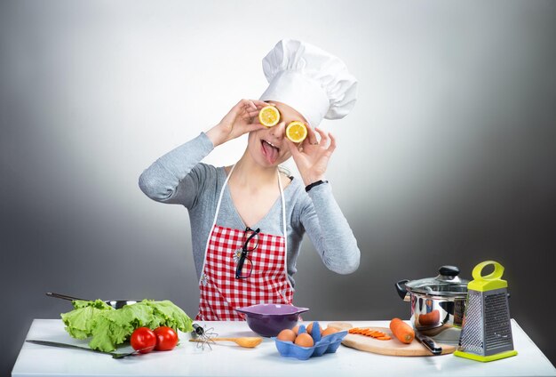 Femme de cuisine folle aux yeux de citron sur fond gris