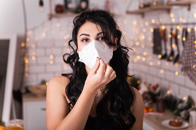 Femme sur la cuisine porter un masque facial