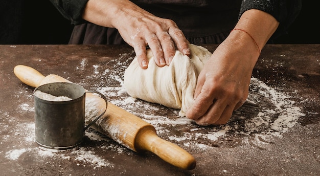 Femme cuisinier pétrir la pâte à pizza