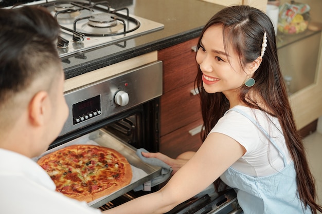 Femme cuit une pizza pour le dîner