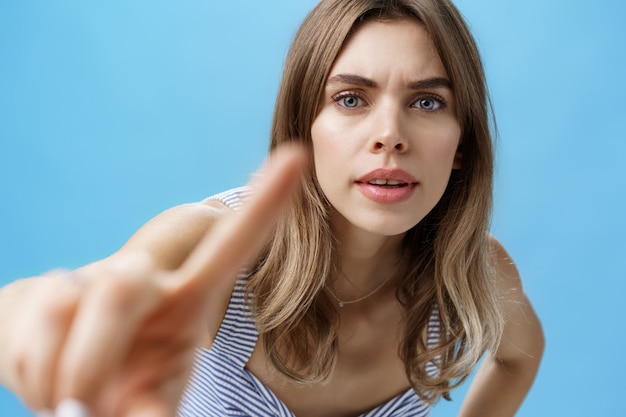 Femme curieuse et intriguée pointant la caméra avec le doigt comme si elle vérifiait quelqu'un qui la regardait...