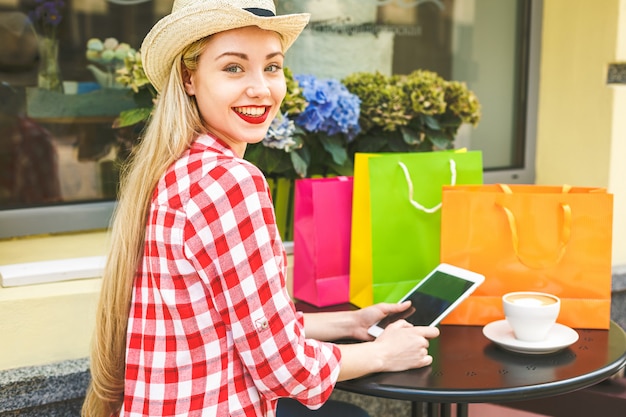Femme dans les achats en ligne. Femme heureuse avec tablette, profitant du shopping.