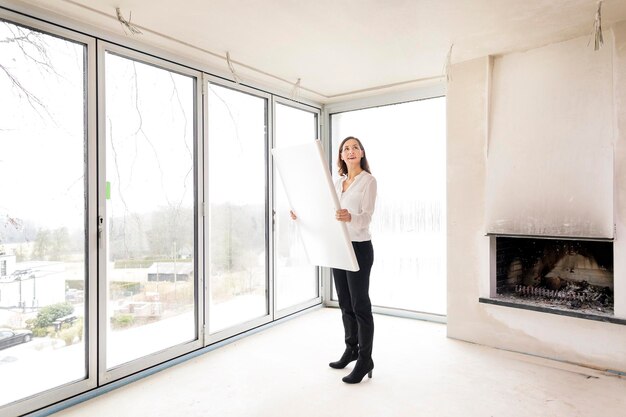 Femme dans un appartement vide avec plan