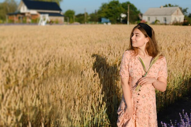 Une femme dans une belle robe dans un champ de seigle le matin