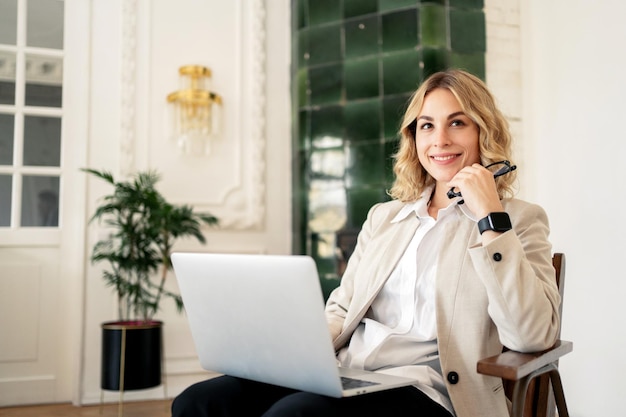 Une femme dans un bureau à domicile est une psychologue en ligne utilisant un ordinateur portable