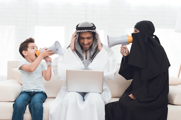 Une femme dans une burqa et un garçon hurlent à un homme.