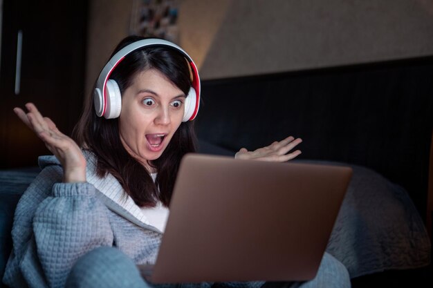 Une femme dans un casque travaillant sur un ordinateur portable a un travail à distance par appel vidéo depuis la maison