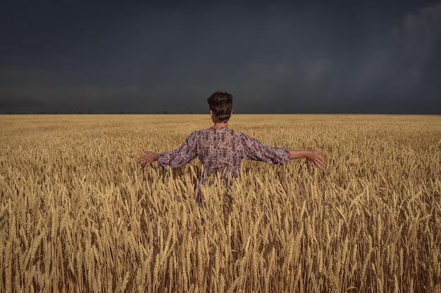 femme dans un champ de blé avant un orage