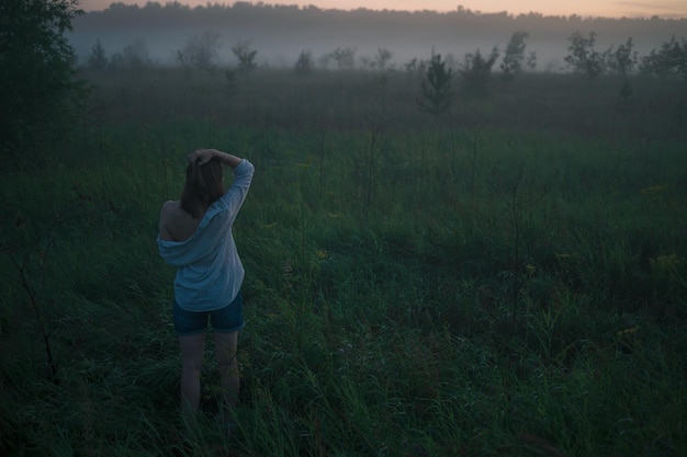 Une femme dans un champ de brouillard brumeux