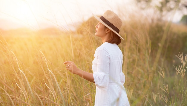 femme avec dans un champ d&#39;herbe dans la soirée