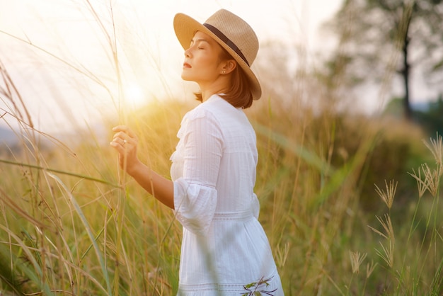 femme avec dans un champ d&#39;herbe dans la soirée