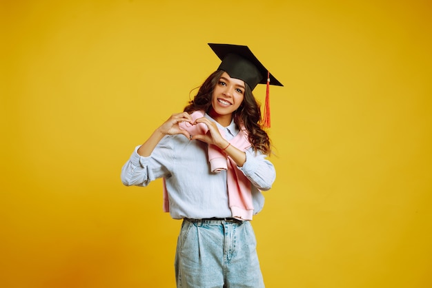 femme dans un chapeau de graduation faisant signe d & # 39; amour