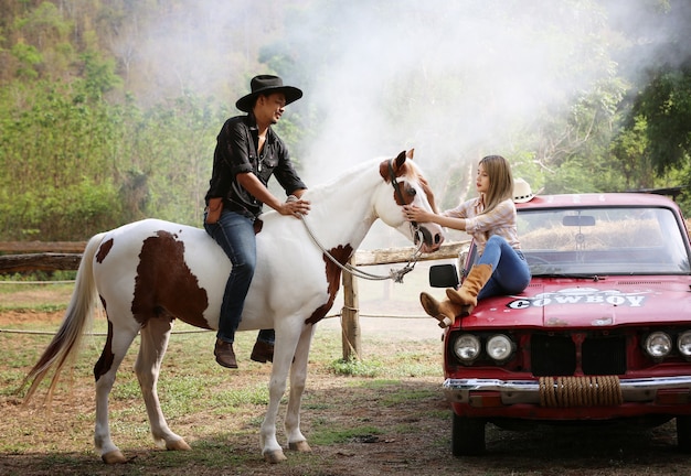 femme dans un costume de style cow-girl se trouve dans un ranch de chevaux avec un environnement de ferme de l'ouest.