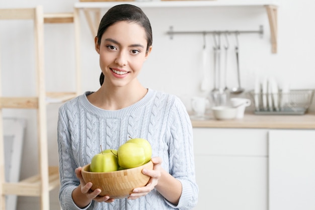 Femme dans la cuisine avec des fruits et autres aliments, mode de vie sain, femme seule à la maison. Prise de vue en studio.