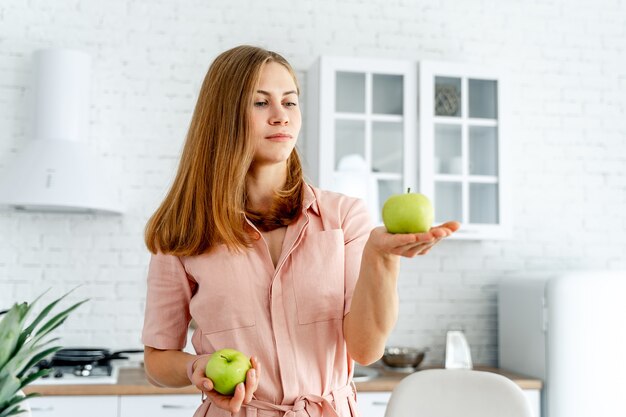 Femme dans la cuisine prête à préparer un repas avec des légumes et des fruits