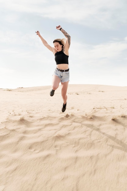 Femme dans le désert poussée à sauter