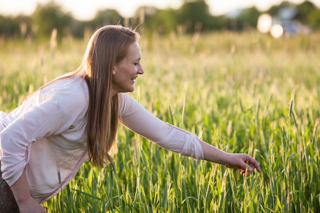 La femme dans le domaine apprécie l'harmonie de blé avec la nature