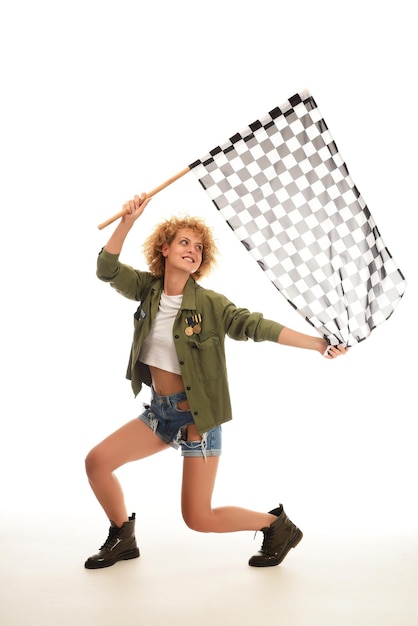 femme dans un drapeau de course à damier agitant isolé sur fond blanc