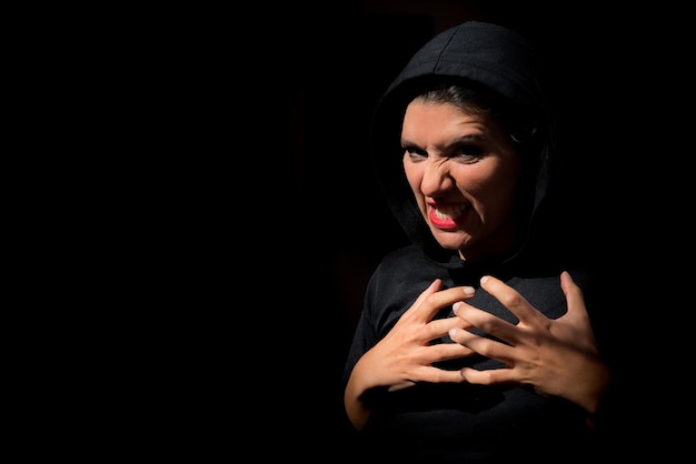 Femme dans l'expression sombre de la terreur fond noir