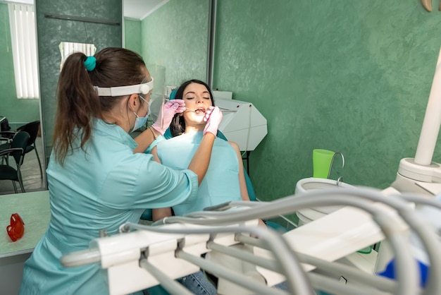 Femme dans le fauteuil du dentiste traitant sa dent sans douleur