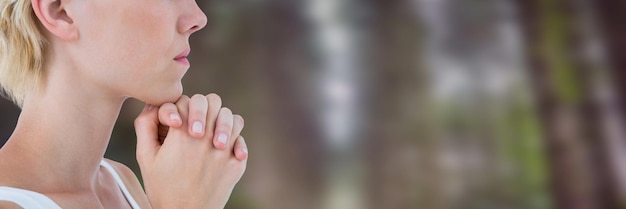 Femme dans la forêt serrant les mains ensemble