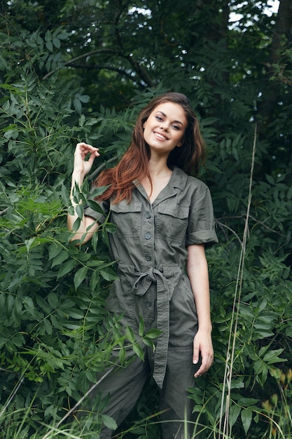 Une femme dans la forêt sourit et leva la main l'été