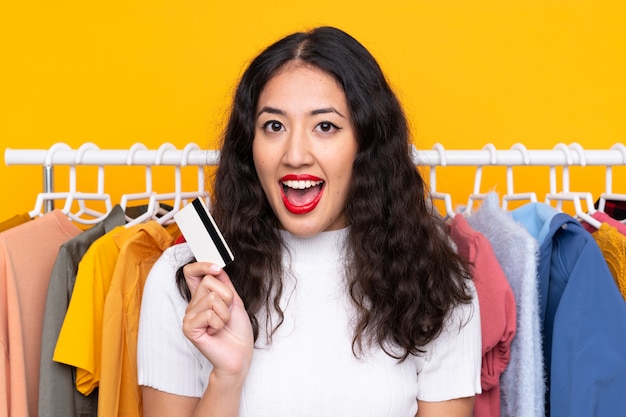 Femme dans un magasin de vêtements et tenant une carte de crédit