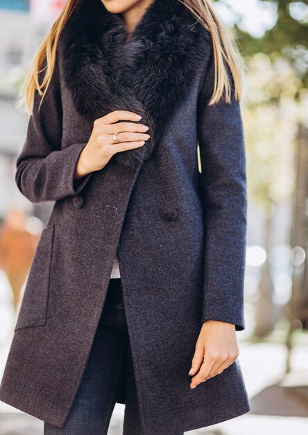 Photo femme dans un manteau d'hiver avec un col de fourrure à l'extérieur