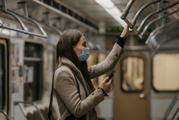 Une femme dans un masque médical à la station de métro