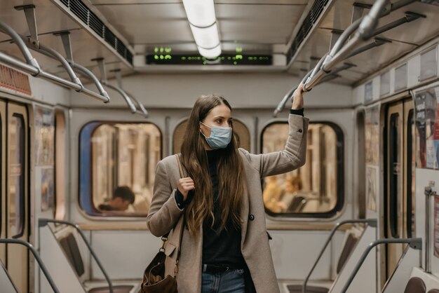 Une femme dans un masque médical à la station de métro