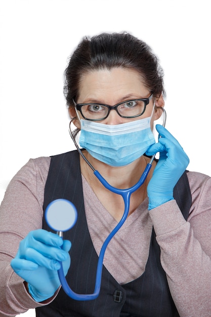 Femme dans un masque avec un phonendoscope dans ses mains