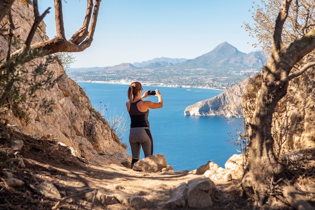 Femme dans les montagnes, prendre des photos et observer le paysage