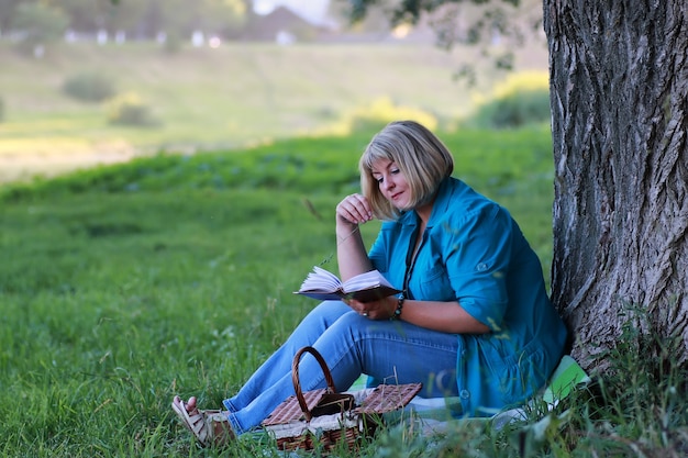 femme dans le parc arbre lecture livre