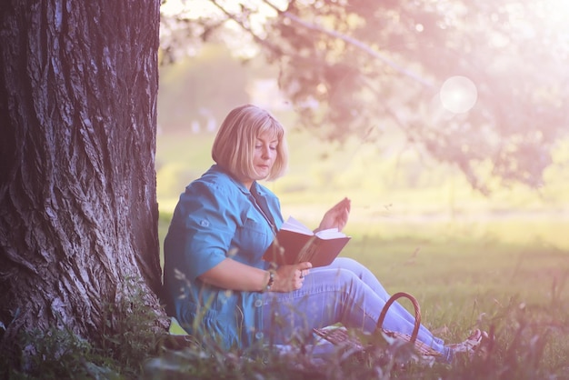 femme dans le parc au coucher du soleil avec livre