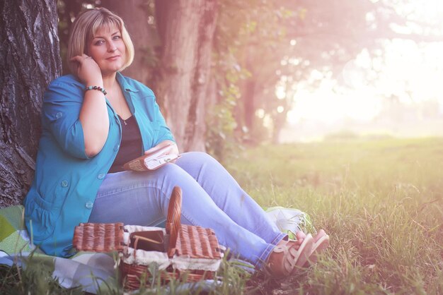 femme dans le parc au coucher du soleil avec livre