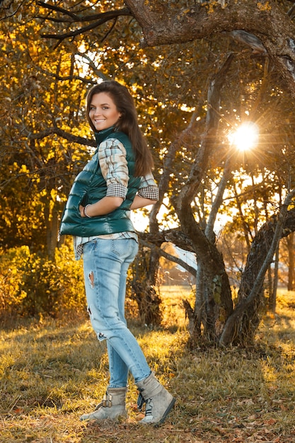 Femme dans le parc au jour d'automne ensoleillé