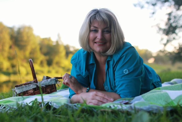 Femme dans le parc avec livre sur l'herbe