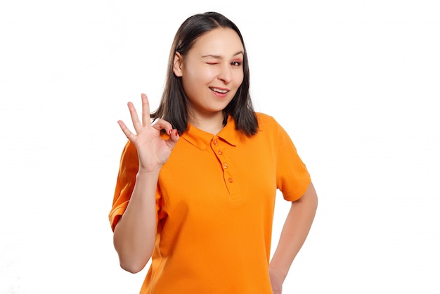 Une femme dans un polo brillant montre un geste correct et sourit