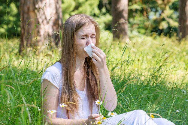 Femme dans le pré éternue, le concept d'une allergie