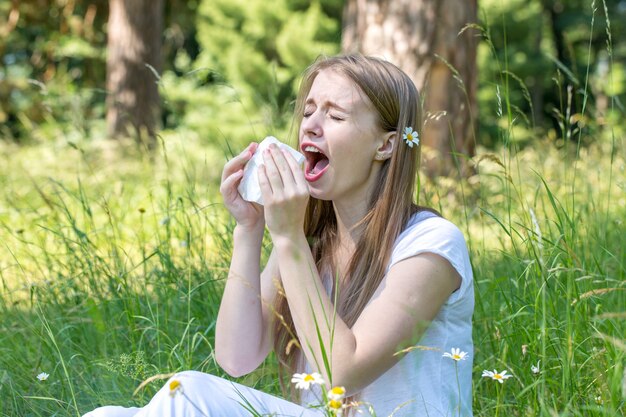 Femme dans le pré éternue, le concept d'une allergie