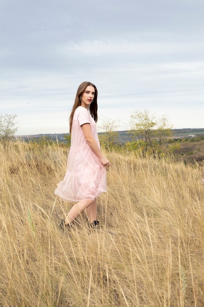 Une femme dans une robe délicate se promène dans la nature