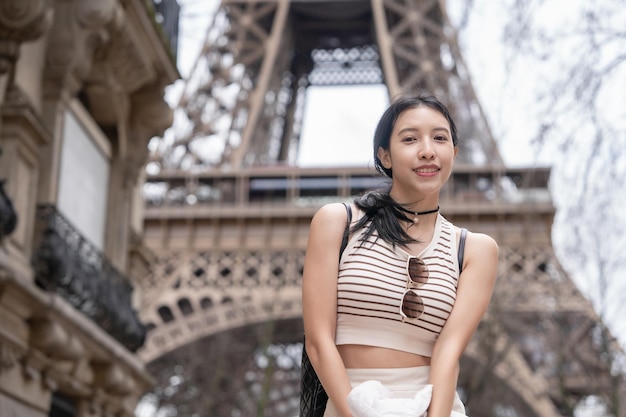 Photo femme dans la rue à paris avec la tour eiffel paris france